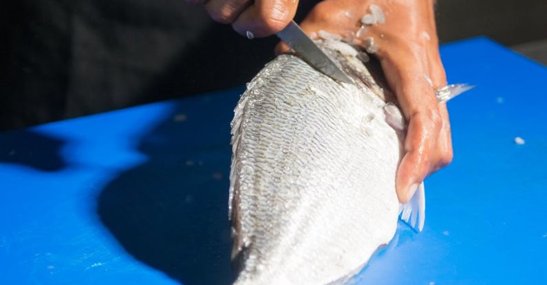 Gluten-free Recipes - A Person Slicing a Fish