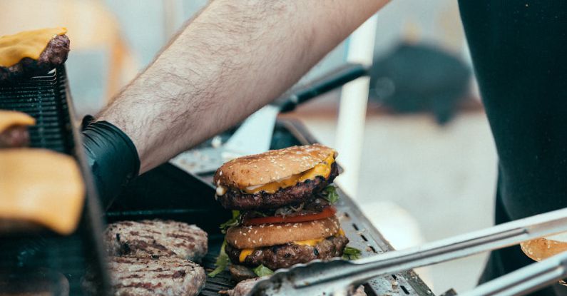 BBQ Favorites - A man is cooking hamburgers on a grill