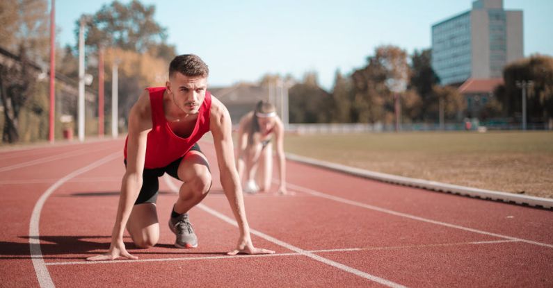 Cardio Exercise - Strong sportsmen ready for running on stadium