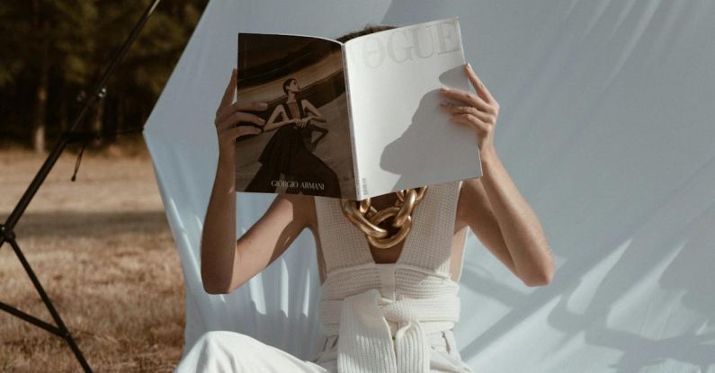 Trendy Hairstyles - Unrecognizable barefoot female covering face with book while reading on white background in nature with tree in summer day outside
