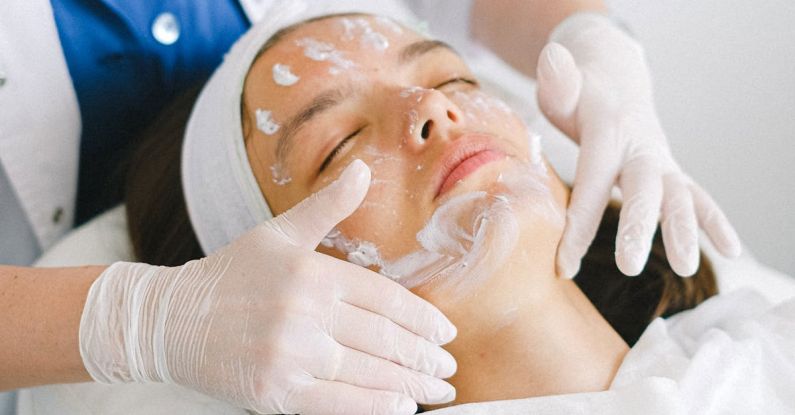 Healthy Boundaries - From above of crop faceless cosmetician applying facial mask on customer face during cosmetic procedure in modern spa salon