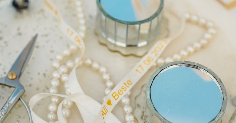 DIY Wedding - Close-up of White Beads and Ribbons Lying on a White Surface with Scissors