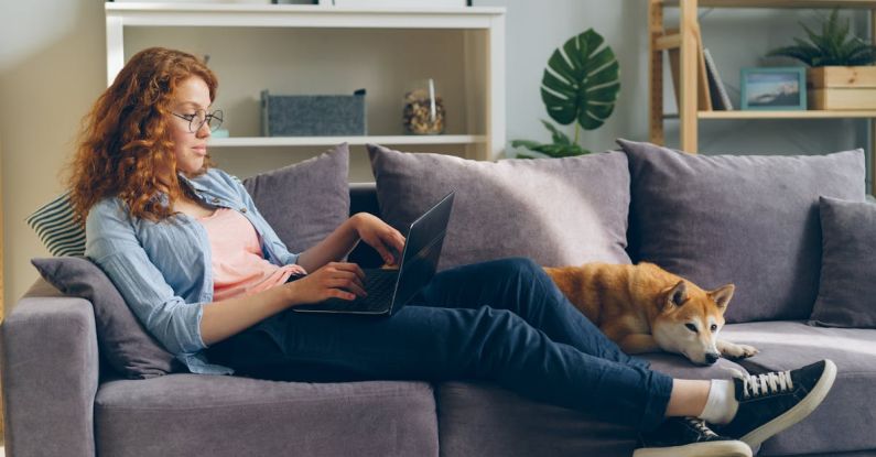 Pet-friendly Home - Woman sitting on couch with laptop and dog