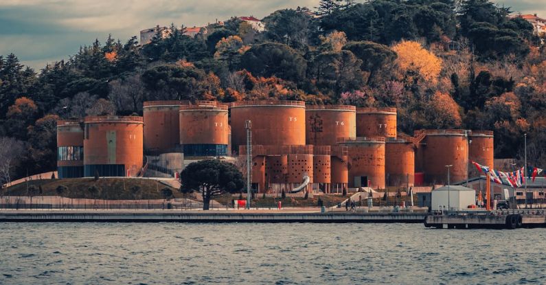 Energy Efficient - A large red building sitting on a hill next to a body of water