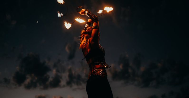 Outdoor Entertaining - Woman in Black and White Floral Dress Holding Fire